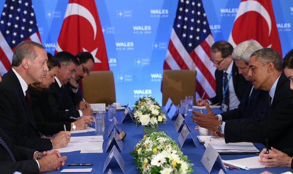 Diplomats from Turkey and the USA in a formal meeting setting.