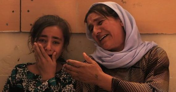 An elderly woman comforts a young girl who looks distressed.