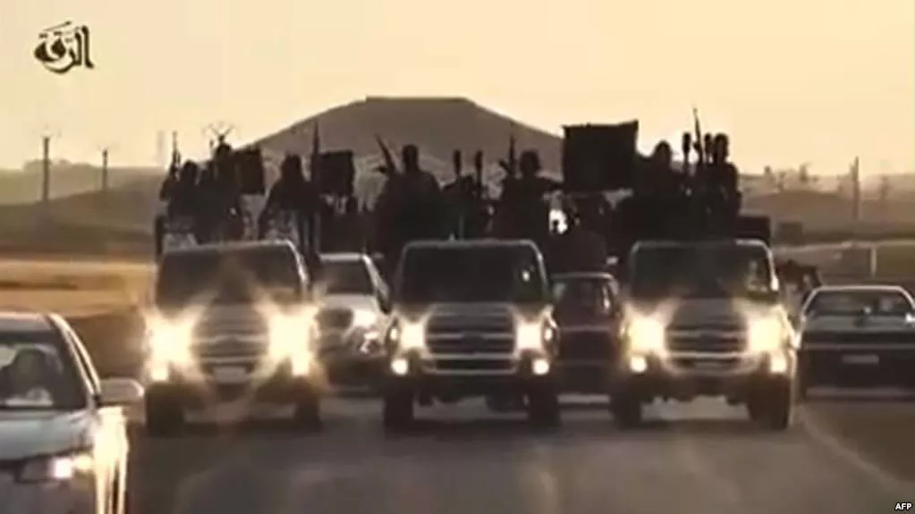 A convoy of vehicles with people raising hands, possibly in celebration or protest.