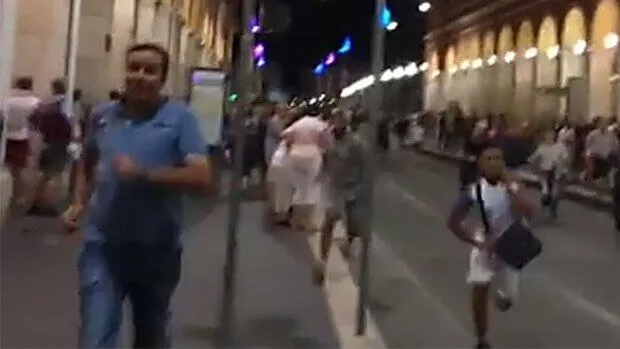 People walking on a lively city street at night.