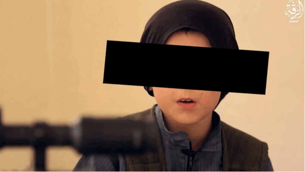 A young person wearing a headscarf holds a firearm, with their eyes blacked out for anonymity.