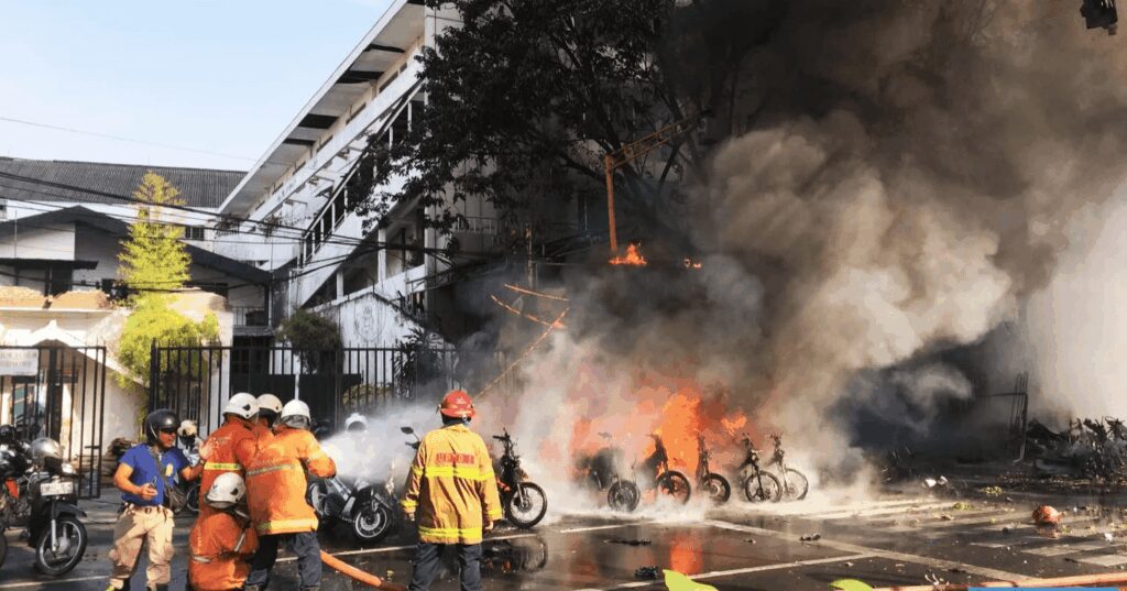 Firefighters combat a large motorcycle fire at an industrial site.