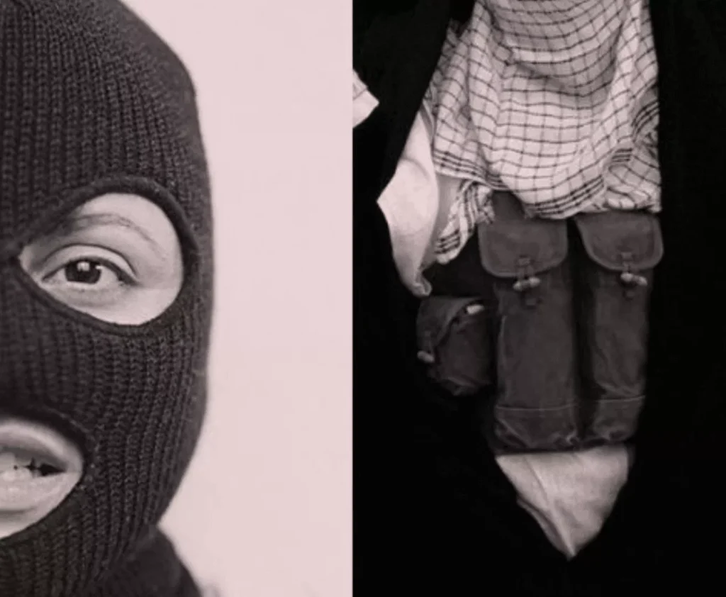 A person wearing a black ski mask and black clothing with tactical gear.