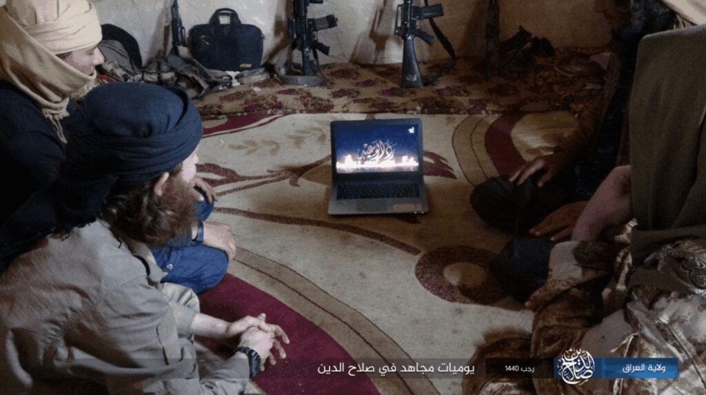 A group watching a movie on a laptop in a cozy room.