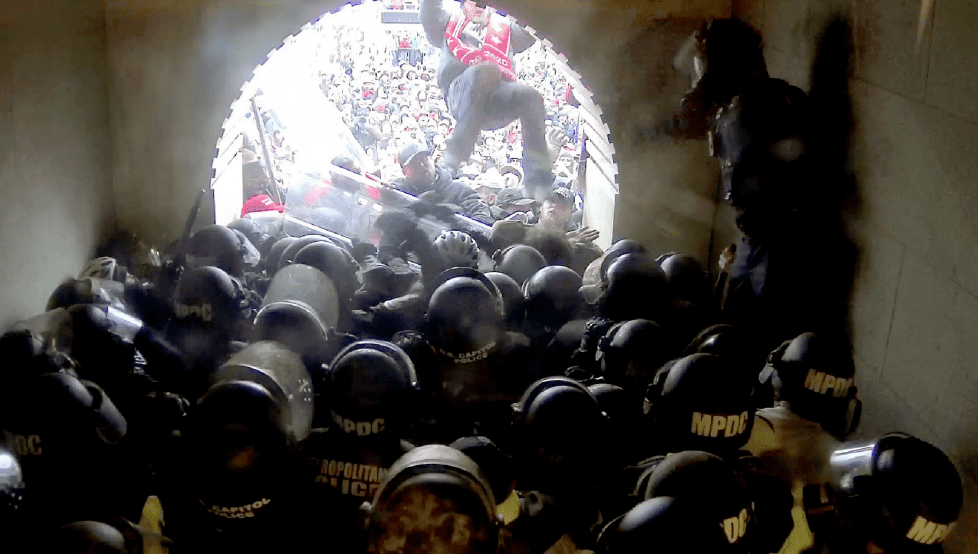 A chaotic clash between police and protesters in a confined tunnel.