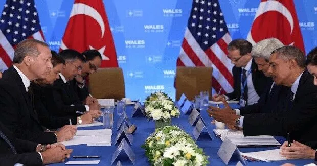 Delegates in a formal meeting with American flags and floral centerpieces.