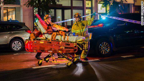 Emergency responders with a stretcher and rescue robot at night.