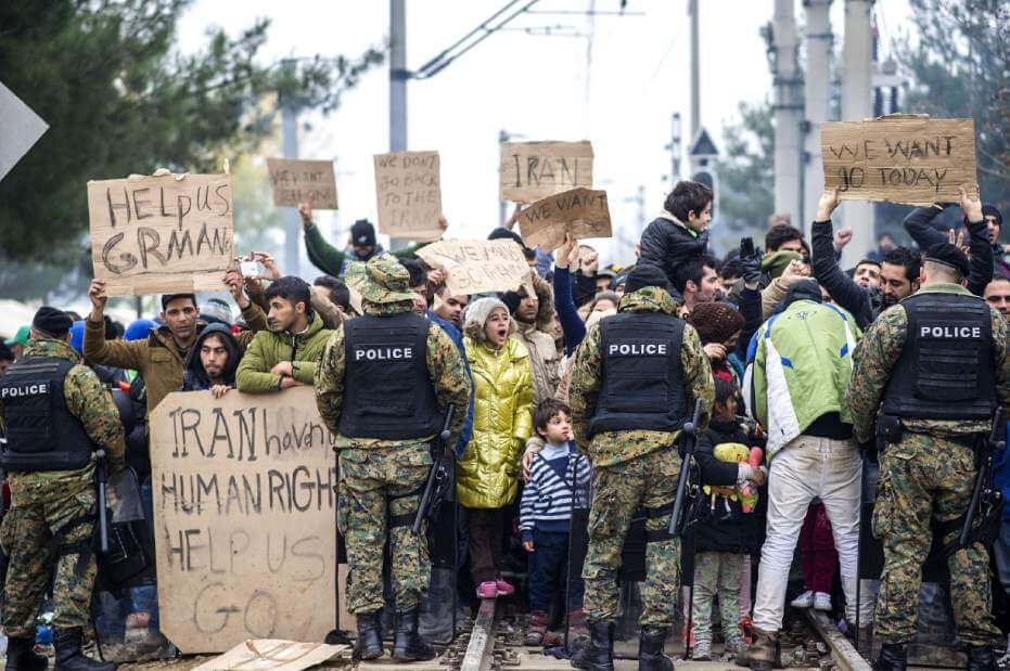 Protesters and police officers stand face-to-face during a public demonstration.