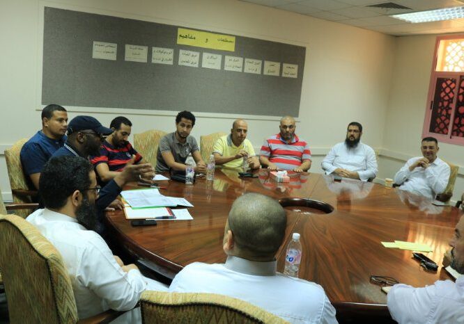 A group meeting in a conference room around a table.