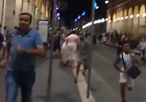 People walking on a lively city street at night.