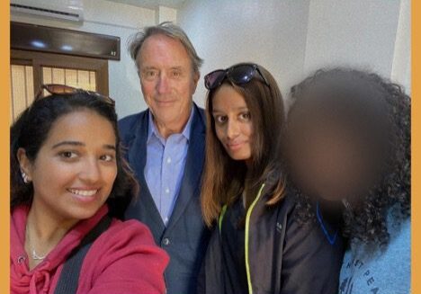 Four people posing for a group selfie indoors.