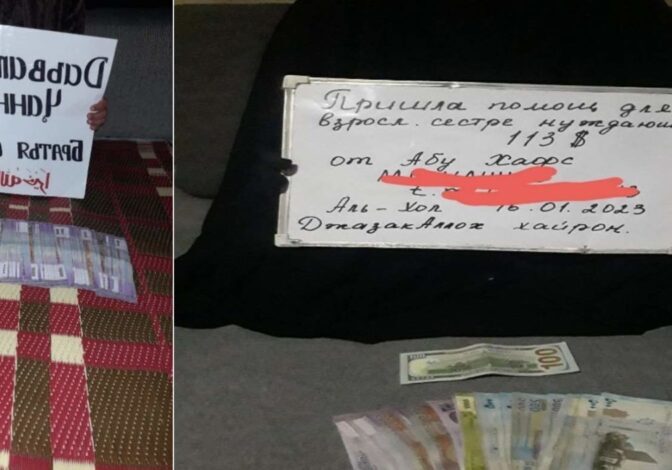A handwritten sign with Russian text and some money on a dark surface.